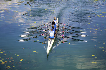 Four women rowing on the tranquil lake - 112610941