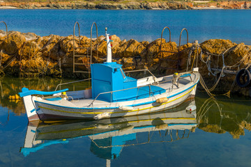 Fototapeta na wymiar Traditional fishing boats in Cyclades, Greece. Bright sunlight r