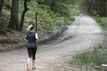 femme qui fait du jogging en pleine forêt