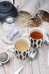 two cups 1 black tea rooibos and other fennel with teapot in the