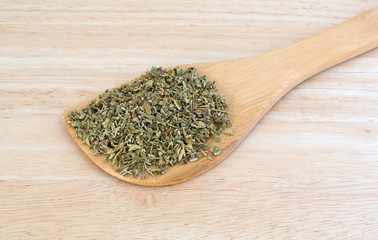 Portion of damiana leaf on a wood spoon atop a counter top