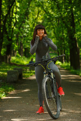 Naklejka na ściany i meble cyclist woman riding a bicycle in park