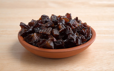 Diced prunes in a small bowl on a table top
