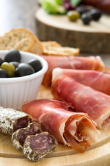 Spanish serrano ham, olives and sausages
on wood