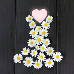 Obraz premium fashionable floral dress from your favorite collection/ flat lay of your favorite summer dress daisies with heart symbol on wooden background