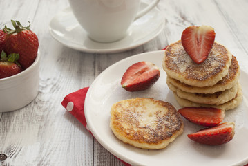 Homemade cottage cheese pancakes with strawberries and powdered