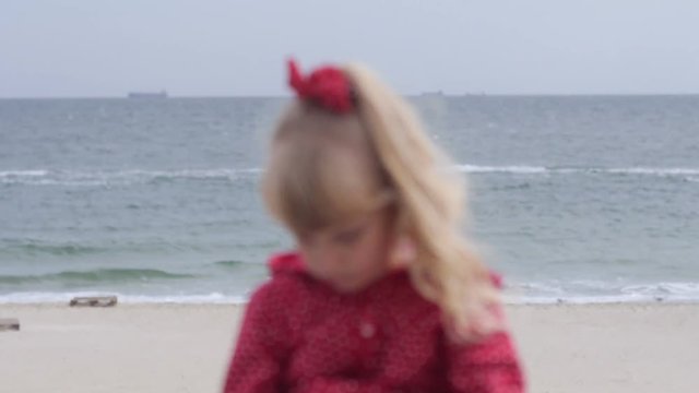 Little girl dreaming at the sea, flipping notebook