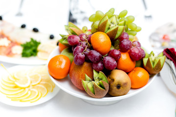 Naklejka na ściany i meble Colorful fruit platter with kiwis mandarins and grapes
