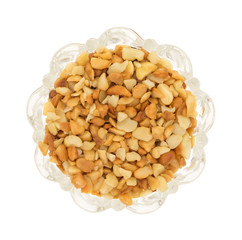 Macadamia nut pieces in a glass bowl on white background
