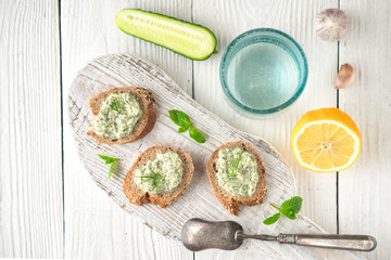 Bread with tzatziki on the white wooden table top view