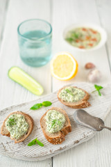 Bread with tzatziki on the white wooden table vertical