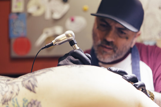 Tattoo artist tattooing a woman