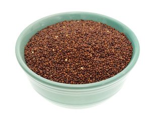Red quinoa in a small bowl isolated on a white background