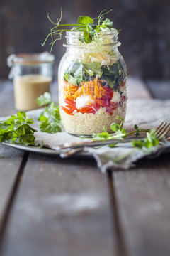 Rainbow salad in a jar, quinoa, tomatoes, mozzarella, spinach, pea sprouts