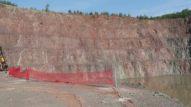BEBERTAL, SAXONY-ANAHLT / GERMANY June 04 2016: Driller in a quarry. view in an open pit mine quarry. porphyry rocks. camera pan.