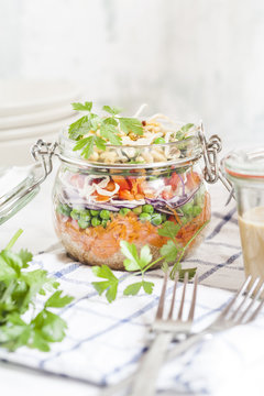Rainbow salad in a jar, quinoa, carrots, peas, red cabbage, bell pepper, mung bean sprouts, dressing aside