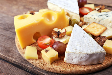 Different kinds of cheese on wooden background