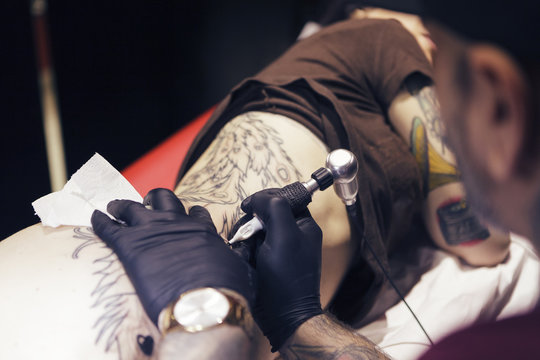 Tattoo artist tattooing a woman