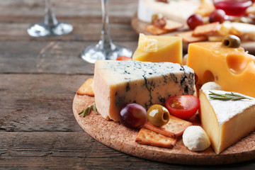 Different kinds of cheese on wooden background