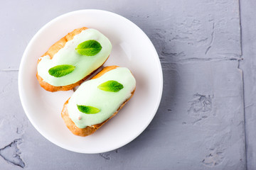 cream dessert eclair with fresh mint leaves