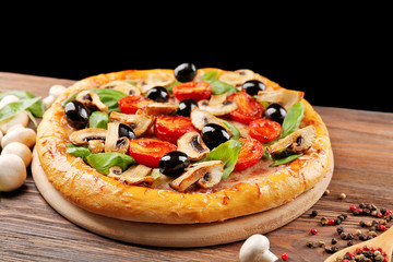 Delicious tasty pizza with ingredients on wooden table