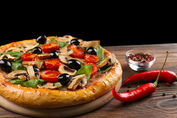 Delicious tasty pizza with ingredients on wooden table