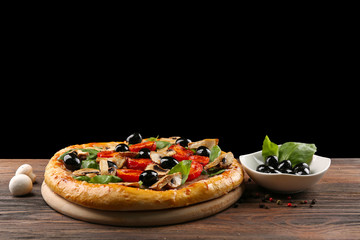 Delicious tasty pizza with ingredients on wooden table