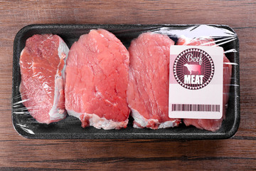 Packed pieces of beef meat on wooden background