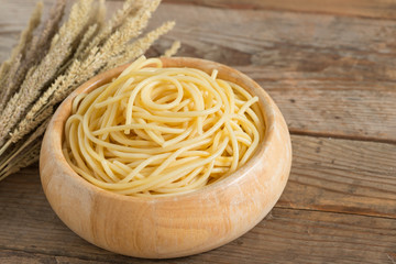 Boiled spaghetti in wood bowl.