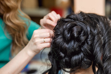 evening hairstyle. brunette doing hairdresser and styling in barber salon