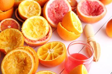Juicing delicious citruses on white wooden background