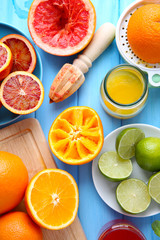Juicing delicious citruses on blue wooden table