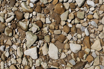 Stones pebbles of different colors and sizes on the river bank