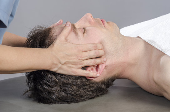 Chiropractor /physioterapist  assessing the muscles on a jaw