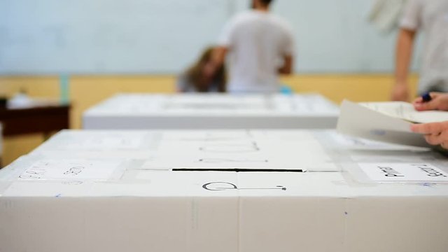 Unrecognizable people casting votes into the ballot box during elections