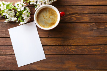 Cup of fresh coffee and note on wooden background