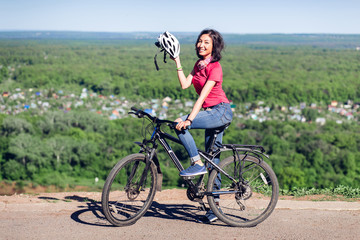 Bike helmet - woman putting biking helmet on during bicycle ride.