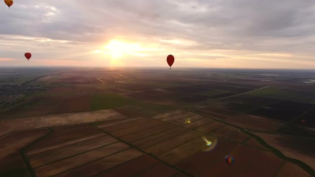 Hot air balloons in the sky over a field in the countryside.Aerial view:Hot air balloons in the sky over a field in the countryside in the beautiful sky and sunset.Aerostat fly in the countryside.