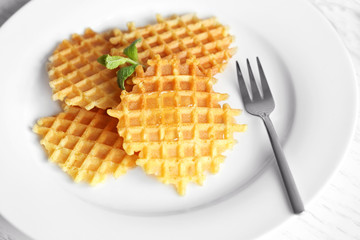 Tasty waffles with honey and mint on plate