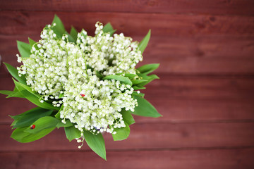 Lily of the valley on wooden background. Lily of the valley bouquet.  Lily of the valley with copy space.