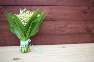 Lily of the valley on wooden background. Lily of the valley bouquet.  Lily of the valley with copy space.