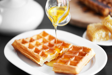 Pouring honey on waffles