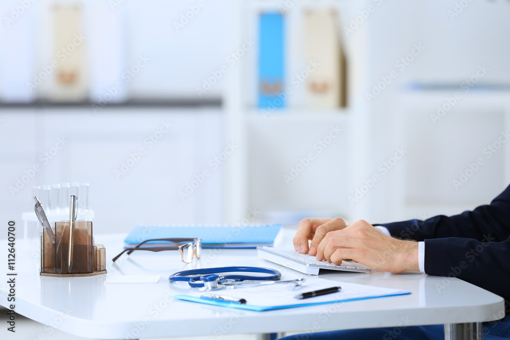 Poster Doctor working at a computer in hospital