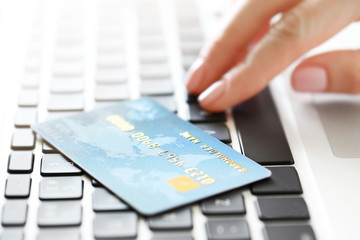 Woman hand and credit card on laptop, closeup