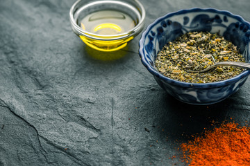 Mixture of spices, chilli, olive oil black shale from the right