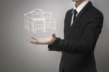 Obraz premium Businessman showing a model of the house