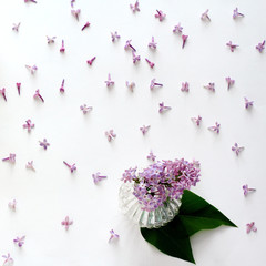 Obraz na płótnie Canvas fresh lilac flowers, vase for decoration, flat lay, top view