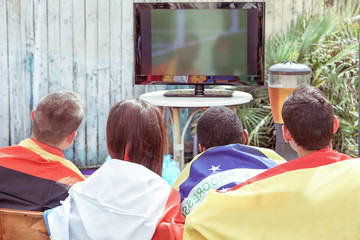 Young football supporter fans watching soccer match 