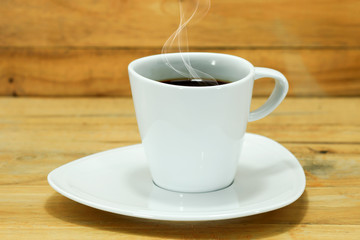 Coffee cup and saucer on a wood.