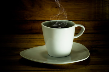 Coffee cup and saucer on a wood.